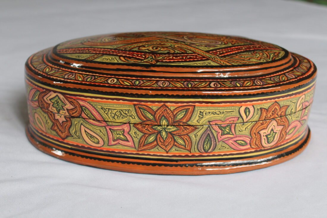Round Kashmiri papier mache jewelry box with hand painted Persian paisley design and lacquered finish